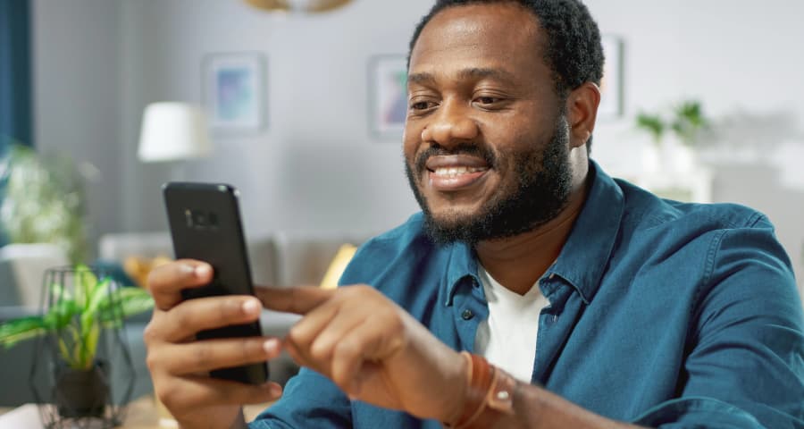 Man at home using an app on his smartphone